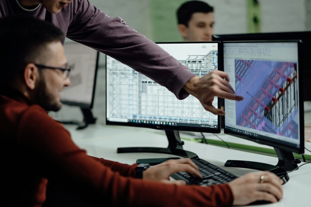 Engineers reviewing a design on screen